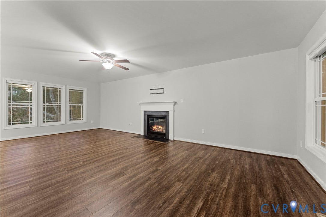 2953 Preston Park Court, Western Goochland County, Goochland, VA 23153 Spacious room featuring wood-finish flooring, a ceiling fan, multiple windows, and a built-in fireplace with a white mantel
