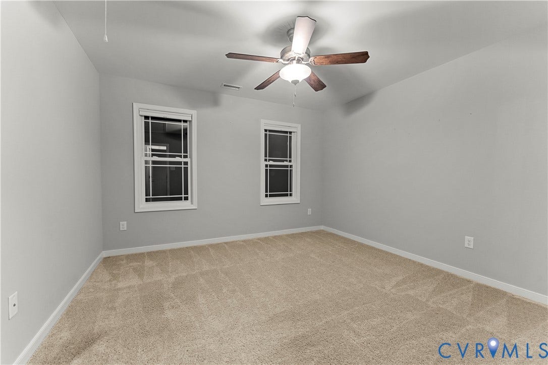 2953 Preston Park Court, Western Goochland County, Goochland, VA 23153 Neutral gray wall paint, two windows with white trim, tan carpeting, and a ceiling fan with wood-finish blades