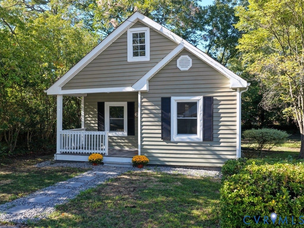 2201 Richmond Street, Hopewell, VA 23860 Gable-roofed home with light green siding, black window shutters, and a covered porch