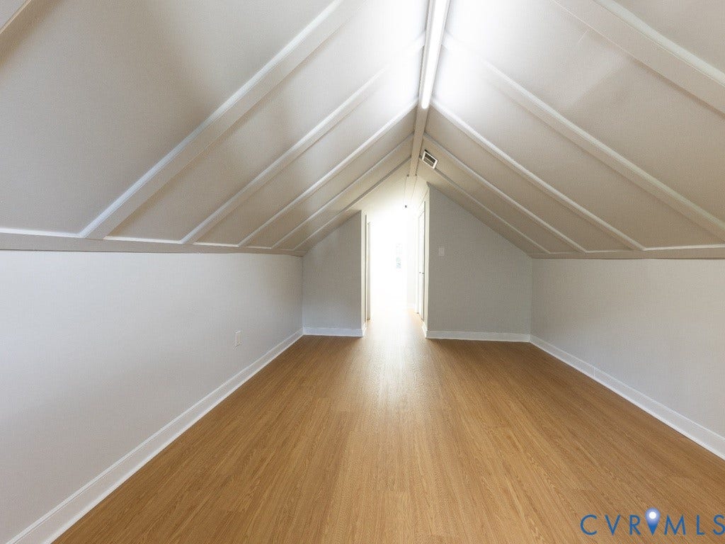 2201 Richmond Street, Hopewell, VA 23860 Attic space featuring wood-finish flooring and a sloped ceiling with decorative trim