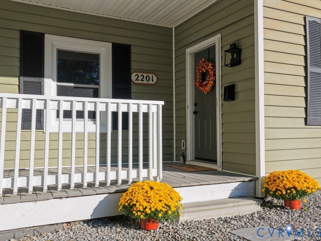 2201 Richmond Street, Hopewell, VA 23860 Covered entry porch with white railing, light olive siding, and a prominent front door with an overhead light fixture