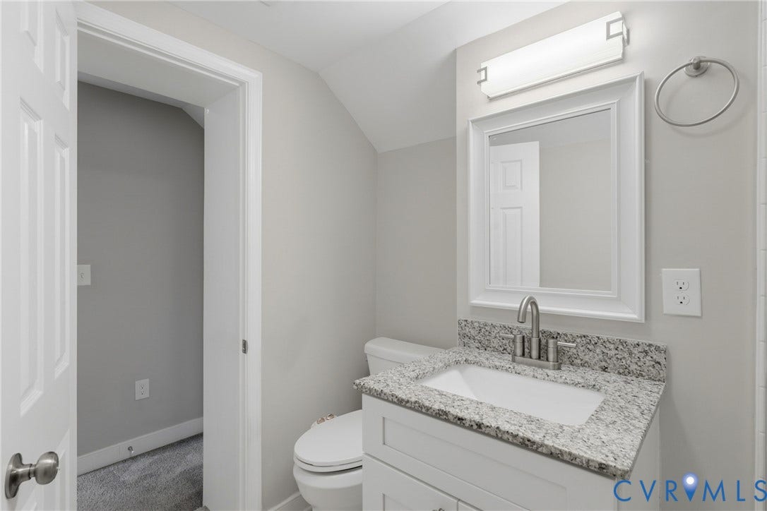 6624 Miller Road, Henrico, VA 23231 Upstairs full bathroom. White vanity with a granite countertop, undermount sink, and brushed nickel faucet