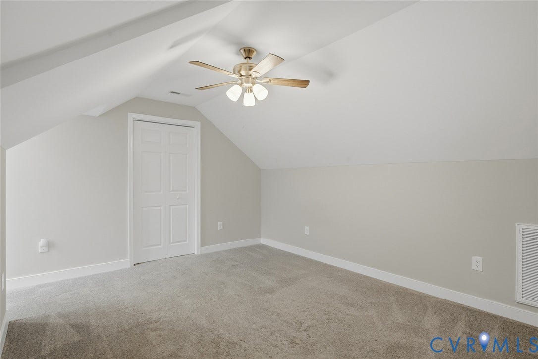 6624 Miller Road, Henrico, VA 23231 Upstairs primary bedroom with full bath.Angled ceilings, neutral wall color, ceiling fan with light kit, walk-in closet, and gray carpet flooring