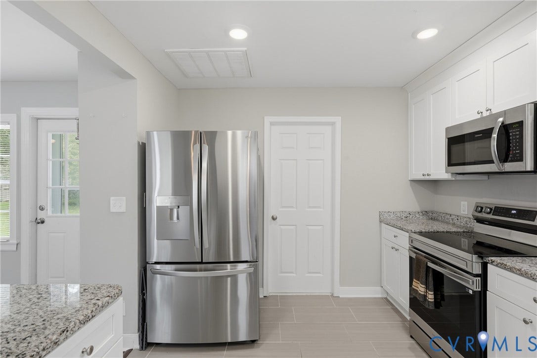 6624 Miller Road, Henrico, VA 23231 Stainless steel appliances, white cabinetry, integrated microwave, light-toned countertops, and light-toned tile flooring