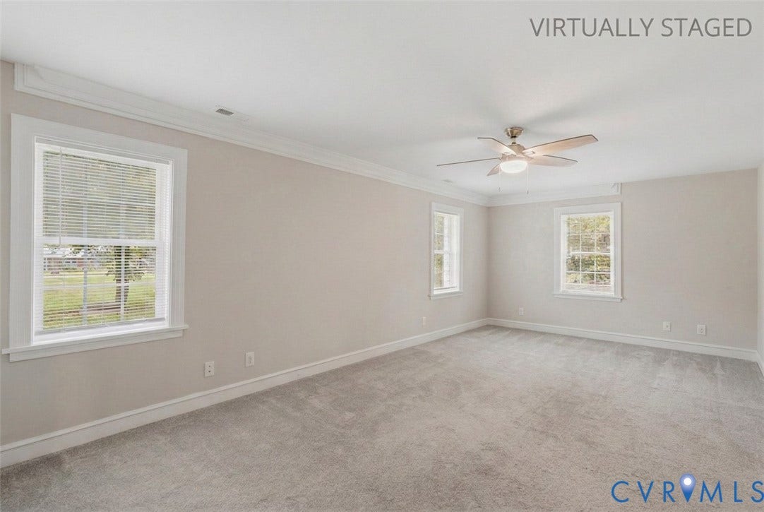 6624 Miller Road, Henrico, VA 23231 The 1st floor primary bedroom is 20 feet long. With crown molding, a ceiling fan, direct access to the primary bathroom, and multiple windows you have plenty of room to create your private oasis. This is a virtually cleared look at the room.
