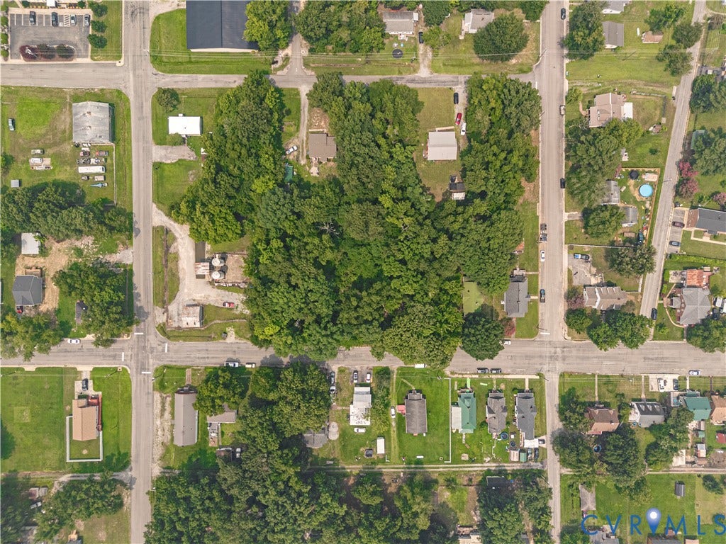 Expansive land parcel featuring dense mature tree coverage, surrounded by residential properties and paved roadways