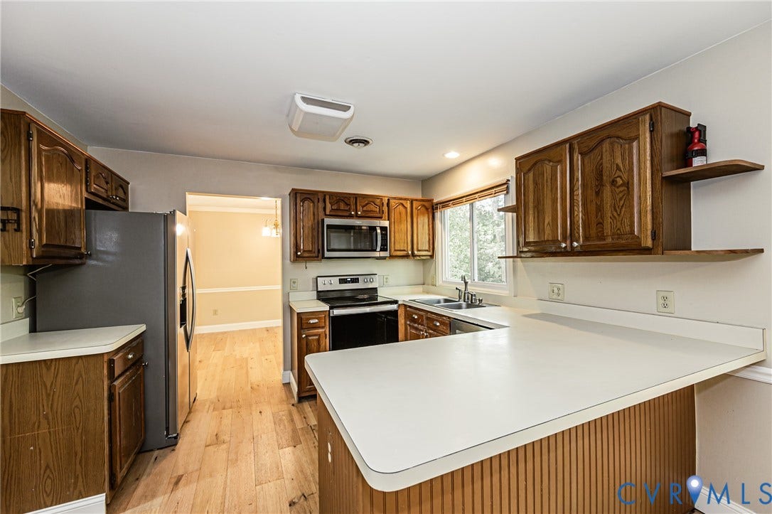 Kitchen featuring wood-finish cabinetry, light wood-finish flooring, and white countertops