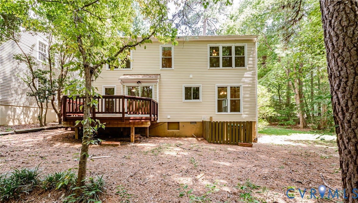Rear exterior with light-colored siding and multiple windows