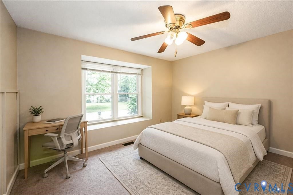 Window with a built-in sill, ceiling fan with light fixture, and neutral-toned carpeting