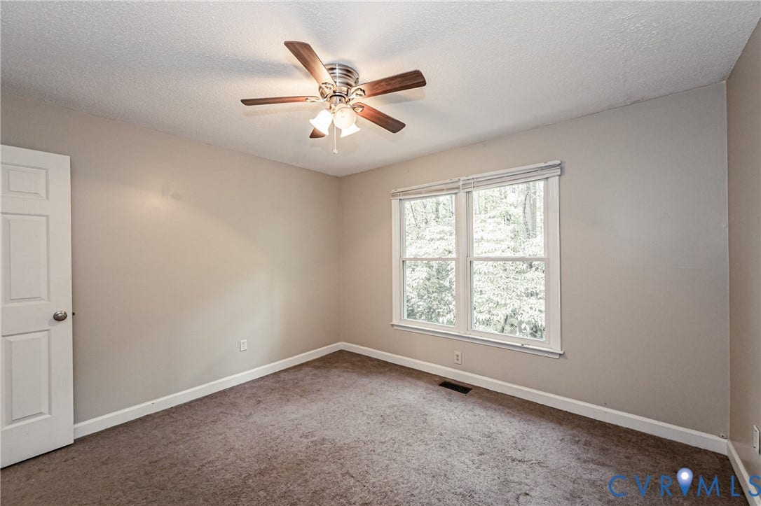 Neutral-toned walls complement plush carpeting