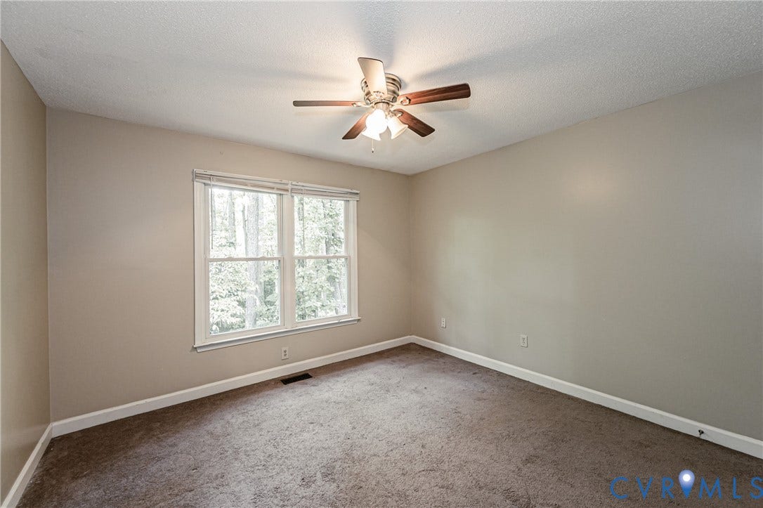 Neutral paint palette with carpeted flooring, featuring a ceiling fan with integrated lighting, and a double window with white blinds