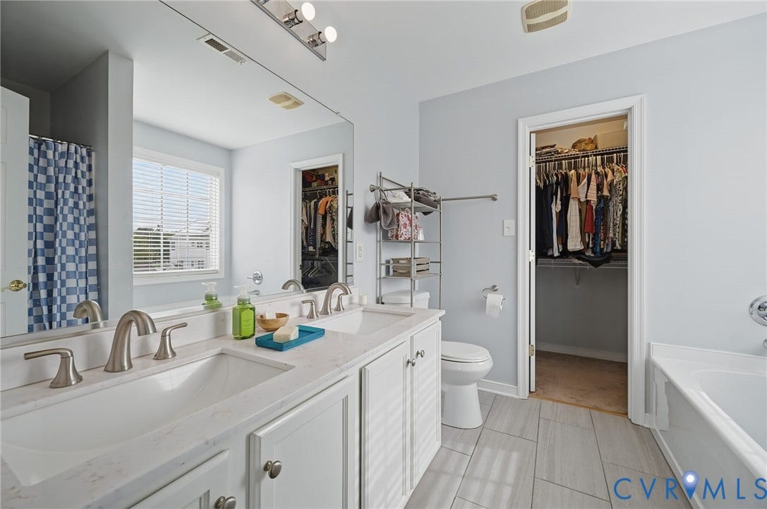 3912 Houze Terrace, Spring Lake, Henrico, VA 23060 Bright, naturally lit bedroom featuring large windows with blue curtains, neutral wall finishes, and ceiling fan with integrated lighting