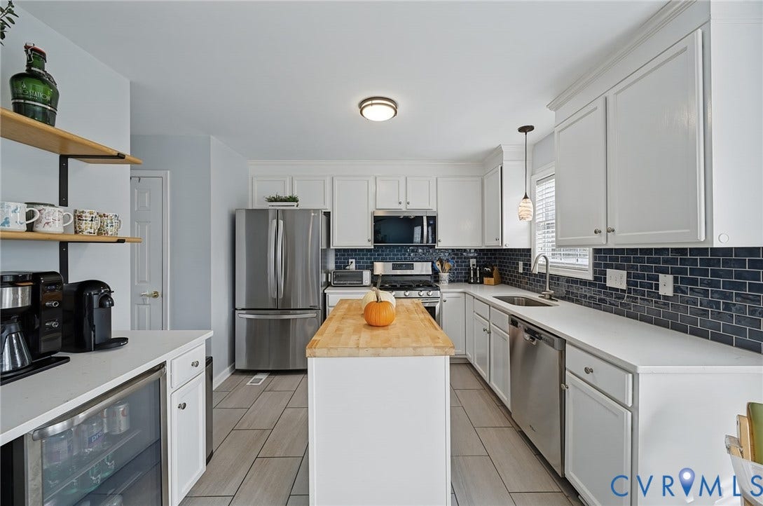 3912 Houze Terrace, Spring Lake, Henrico, VA 23060 White cabinetry, stainless steel appliances, dark subway tile backsplash, light countertops, and wood-finish flooring