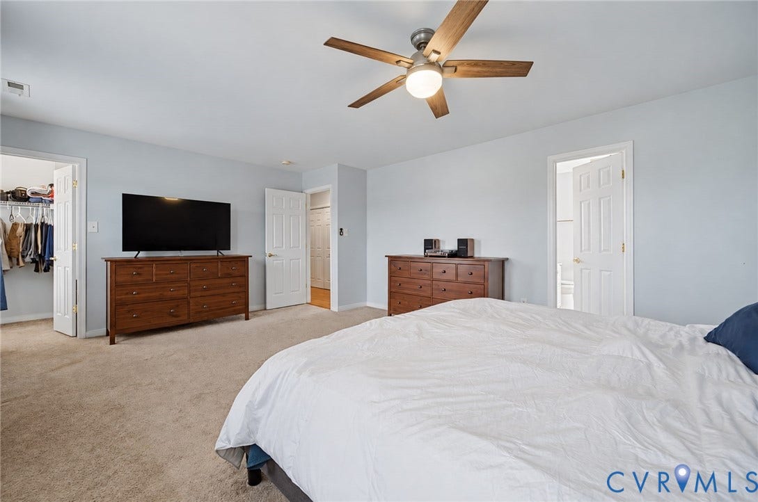 3912 Houze Terrace, Spring Lake, Henrico, VA 23060 Spa-inspired primary bathroom featuring a double vanity with white cabinetry and quartz countertop, soaking tub with checkered shower surround, wood-finish flooring, and abundant natural light from multiple windows