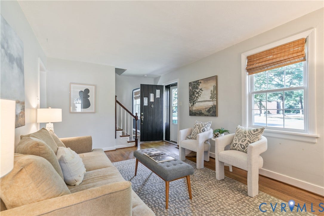 2207 Locbury Lane, Henrico, VA 23228 Living area featuring wood-finish flooring, a multi-pane window with woven-texture blinds, and a staircase with a wooden handrail and white balusters