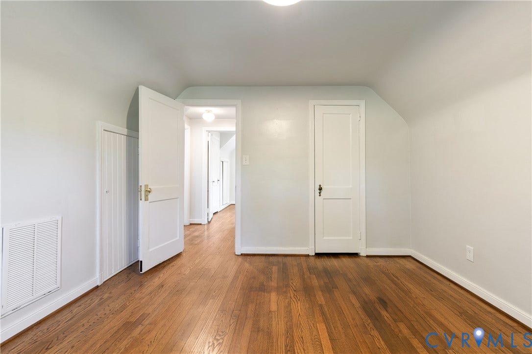 2207 Locbury Lane, Henrico, VA 23228 Interior space featuring wood-finish flooring, vaulted ceilings, classic paneled doors with brass hardware, and built-in storage access