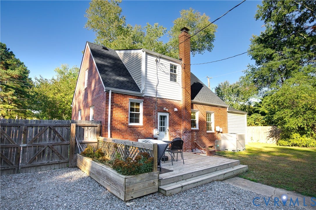 2207 Locbury Lane, Henrico, VA 23228 Brick and white siding exterior featuring a multi-level wood deck, built-in planter boxes with lattice accents, a prominent masonry chimney, and fenced grounds