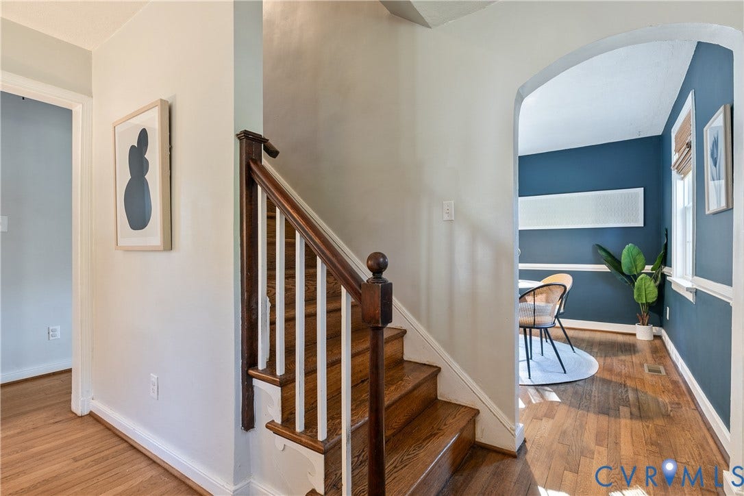 2207 Locbury Lane, Henrico, VA 23228 Staircase featuring wood-finish treads and a dark wood banister with white balusters, arched entryway, and wood-finish flooring