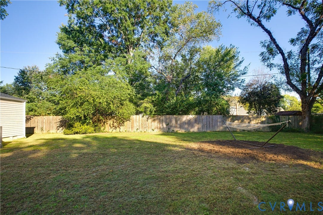 2207 Locbury Lane, Henrico, VA 23228 Backyard space featuring a grass lawn, wood-panel fencing, and mature trees