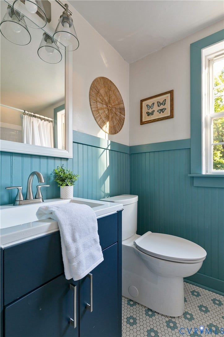 2207 Locbury Lane, Henrico, VA 23228 Bathroom featuring beadboard wainscoting, vanity cabinet with integrated sink, polished metal faucet, three-light vanity fixture, and patterned hexagonal tile flooring