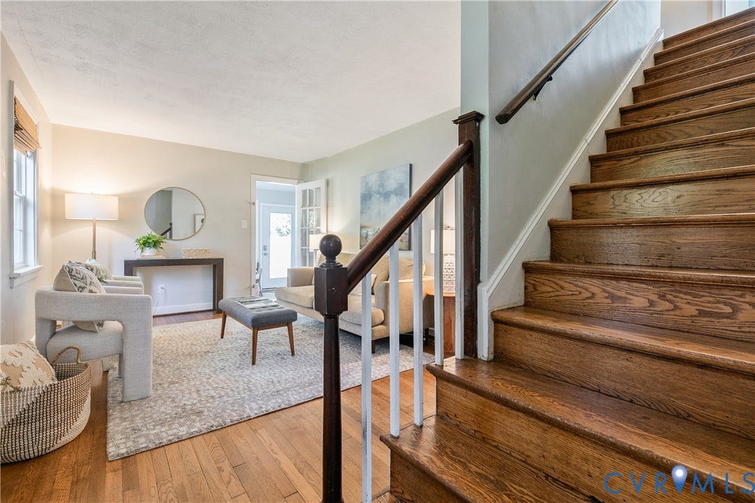 2207 Locbury Lane, Henrico, VA 23228 Staircase featuring wood treads and a handrail with white balusters, wood-finish flooring, and natural light exposure