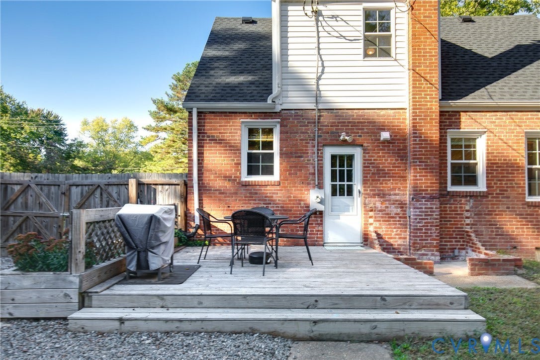 2207 Locbury Lane, Henrico, VA 23228 Exterior wood deck with tiered stairs, red brick facade, white siding, grid-patterned glass door, and wooden lattice fencing
