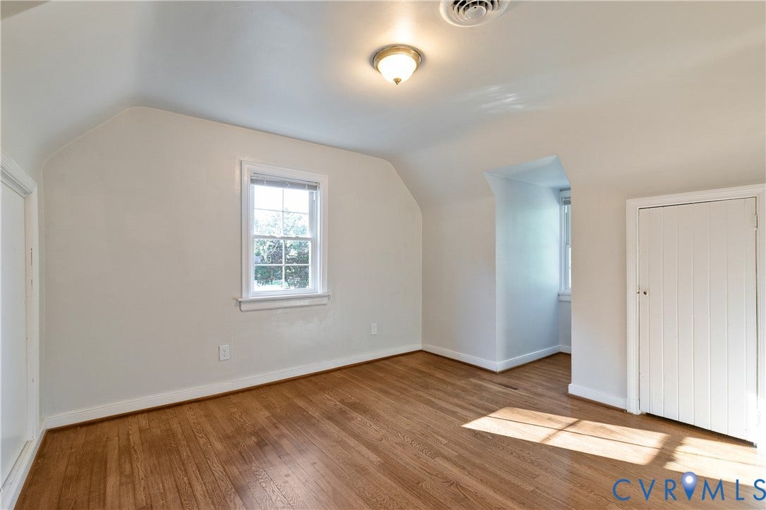 2207 Locbury Lane, Henrico, VA 23228 Interior space featuring wood-finish flooring, vaulted ceilings, dual double-hung windows, and a built-in vertical storage closet
