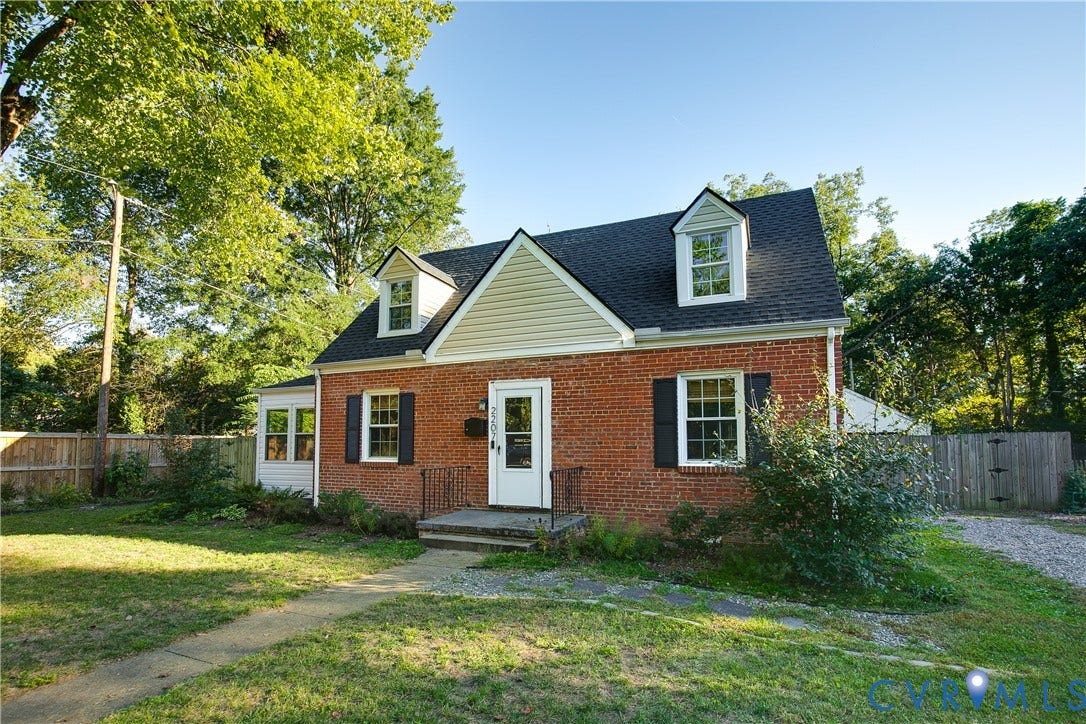 2207 Locbury Lane, Henrico, VA 23228 Classic brick exterior featuring dual gabled dormers, multi-pane windows with dark shutters, and a covered entry with wrought iron railing