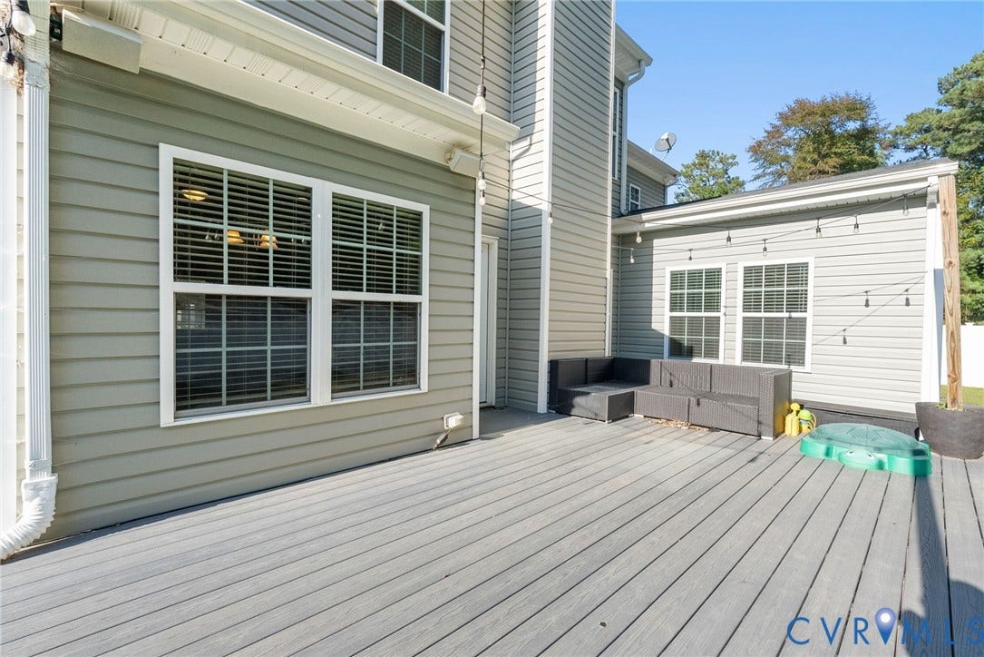 6852 Watch Harbour Circle, Hayes, VA 23072 Expansive composite deck with light gray siding, multiple windows with blinds, and white trim accents