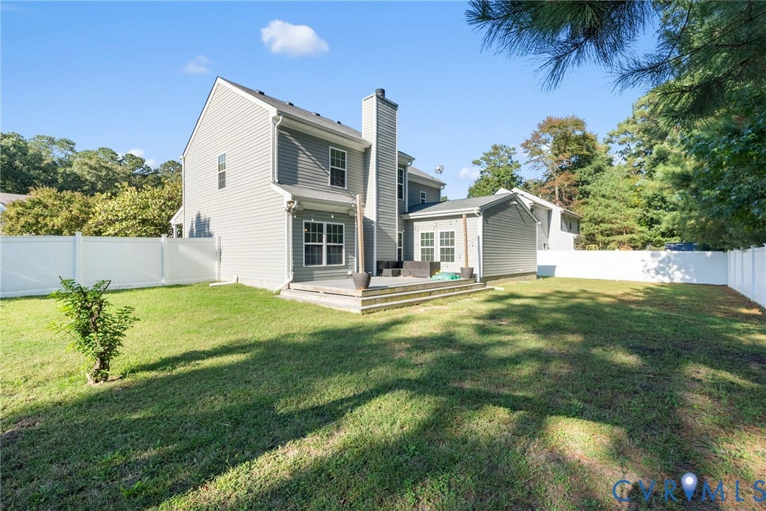 6852 Watch Harbour Circle, Hayes, VA 23072 Expansive backyard featuring a manicured lawn, a white privacy fence, and a multi-level wood deck