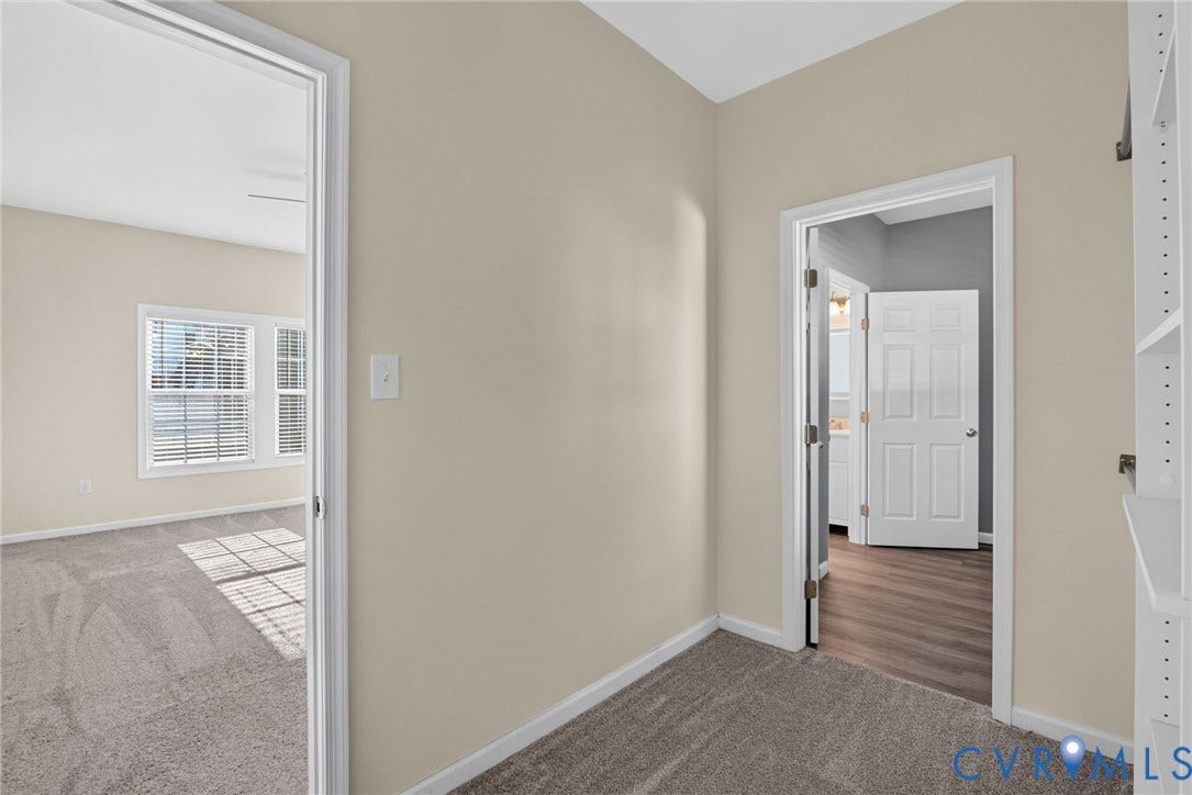 6852 Watch Harbour Circle, Hayes, VA 23072 Neutral wall paint, carpet flooring, interior doorway, built-in shelving, wood-finish flooring