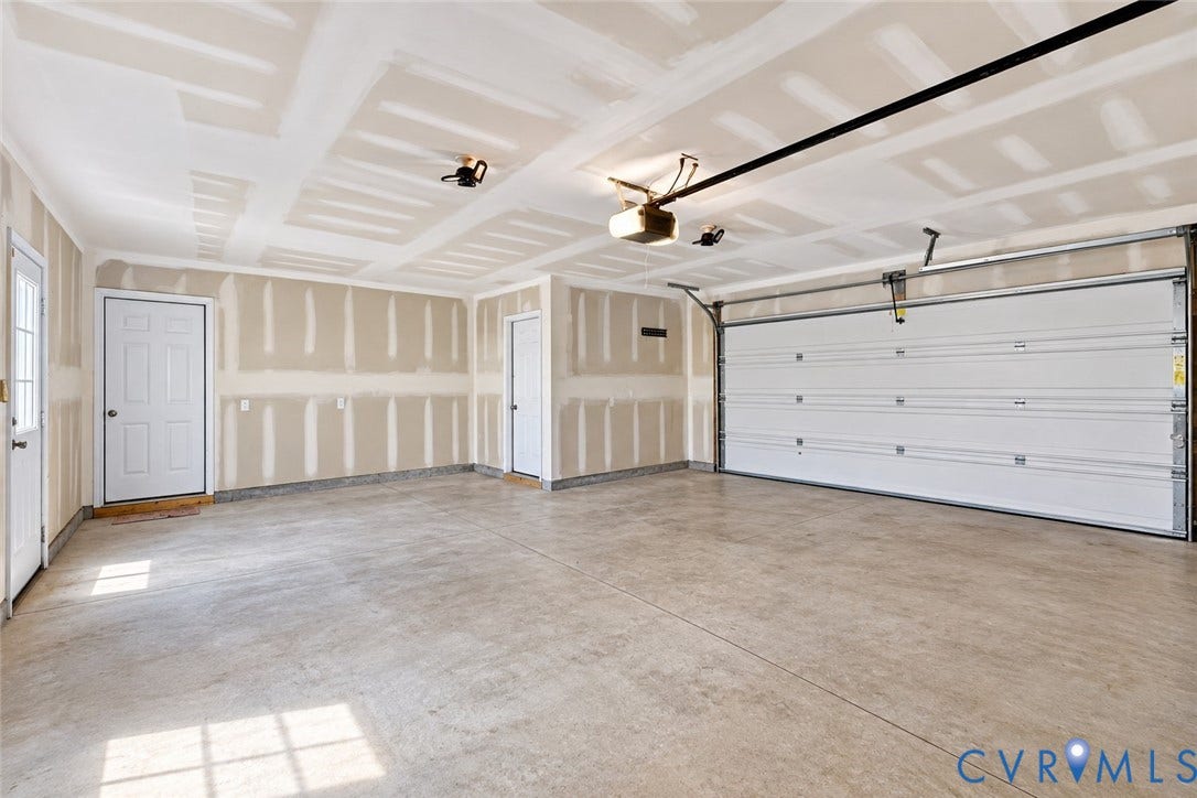 6852 Watch Harbour Circle, Hayes, VA 23072 Concrete flooring, white panel garage door, multiple entry doors, exposed drywall, overhead garage door opener