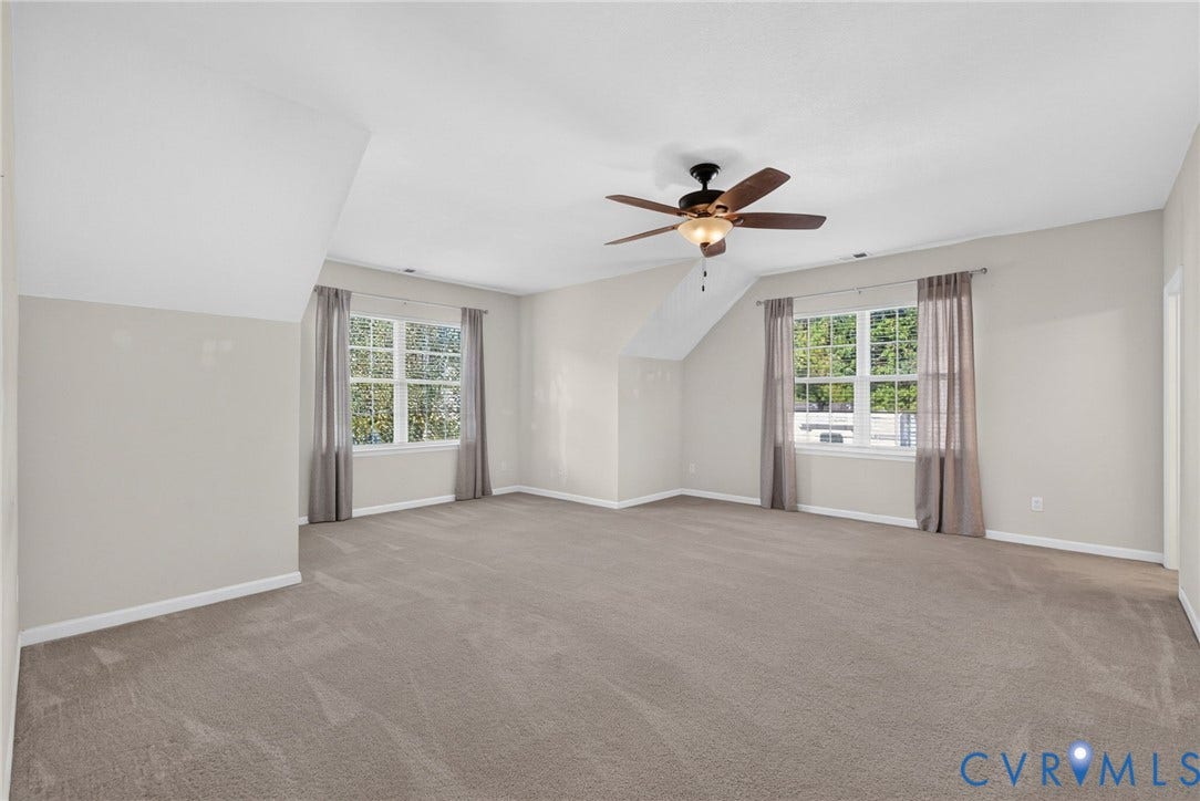 6852 Watch Harbour Circle, Hayes, VA 23072 Expansive room featuring neutral carpeting, a ceiling fan with integrated lighting, and two multi-pane windows