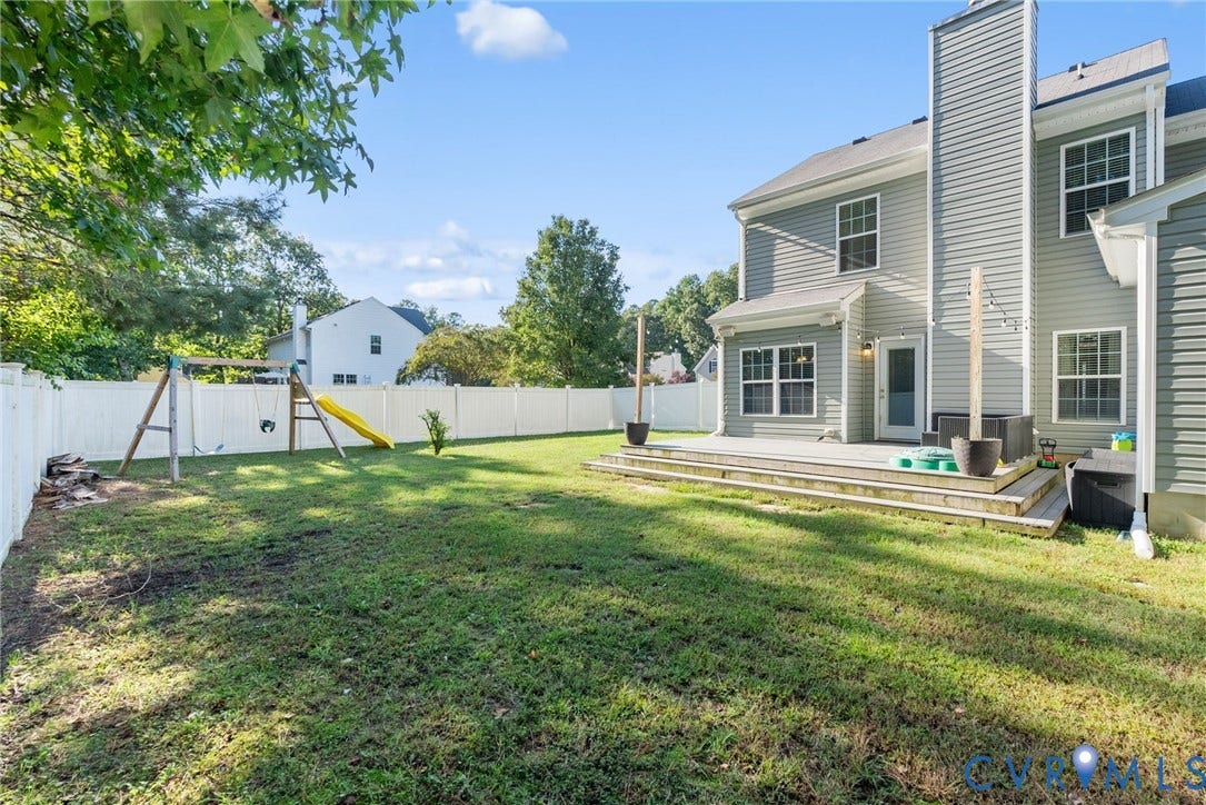 6852 Watch Harbour Circle, Hayes, VA 23072 Spacious backyard with a white privacy fence, multi-level wood deck, and siding exterior