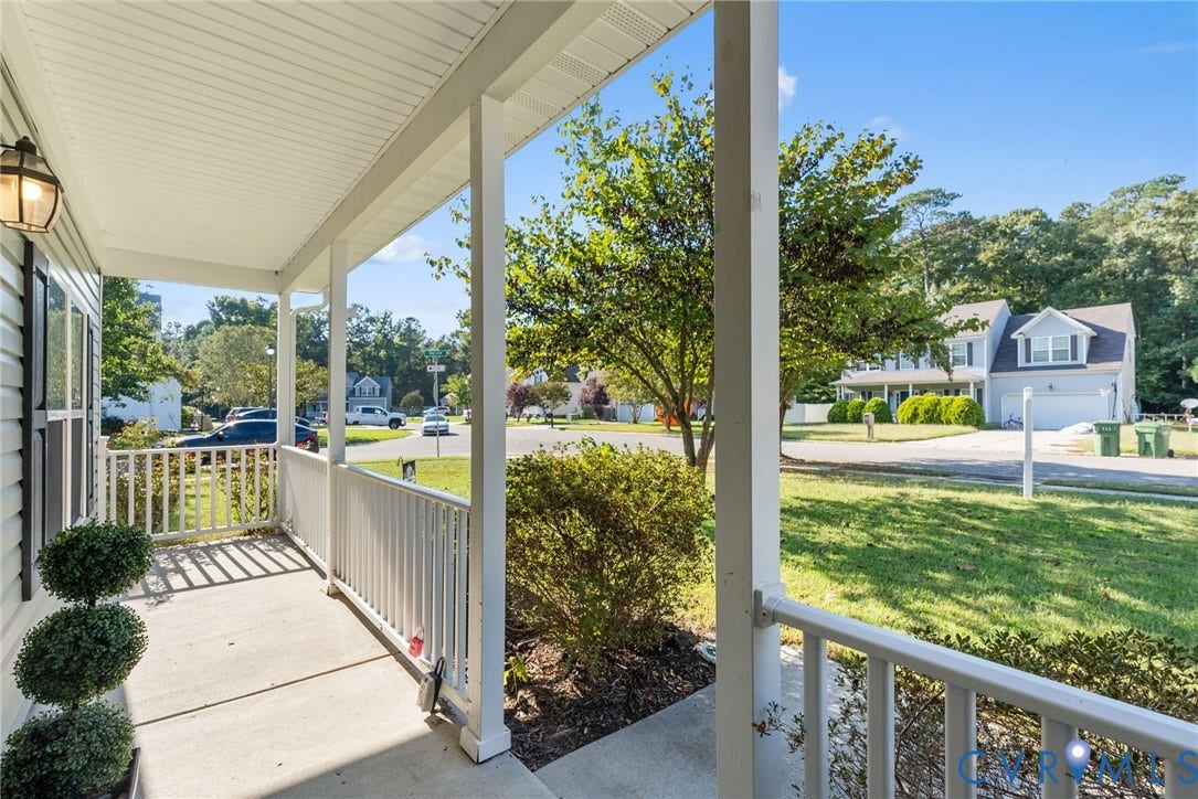 6852 Watch Harbour Circle, Hayes, VA 23072 Covered front porch with white railings and an attached exterior light fixture