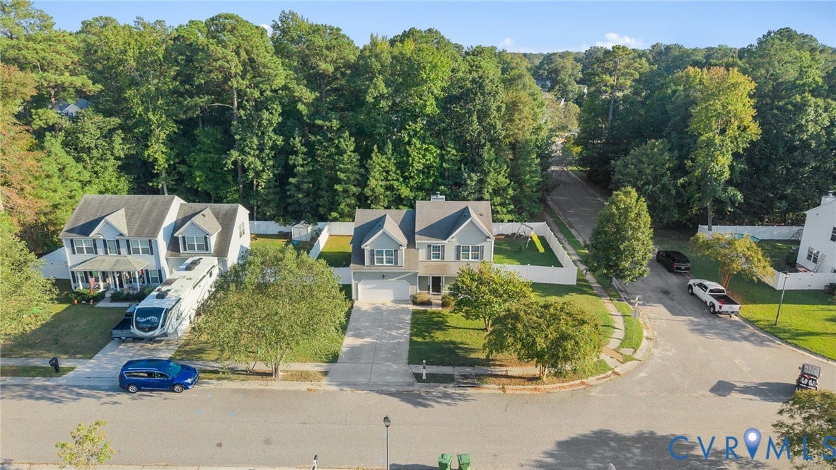 6852 Watch Harbour Circle, Hayes, VA 23072 Two-story residence featuring a two-car garage, front porch, and a white privacy fence encompassing the backyard