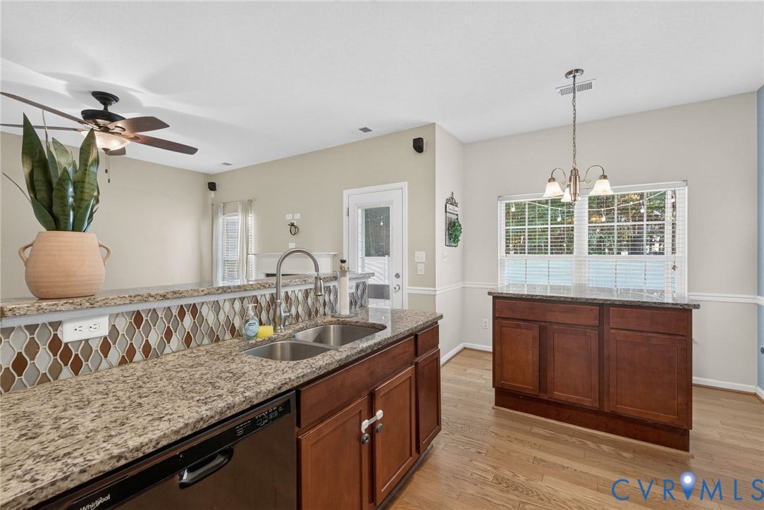 6852 Watch Harbour Circle, Hayes, VA 23072 Kitchen with granite countertops, a double-basin stainless steel sink, wood-finish flooring, dark wood cabinetry, and a decorative tile backsplash