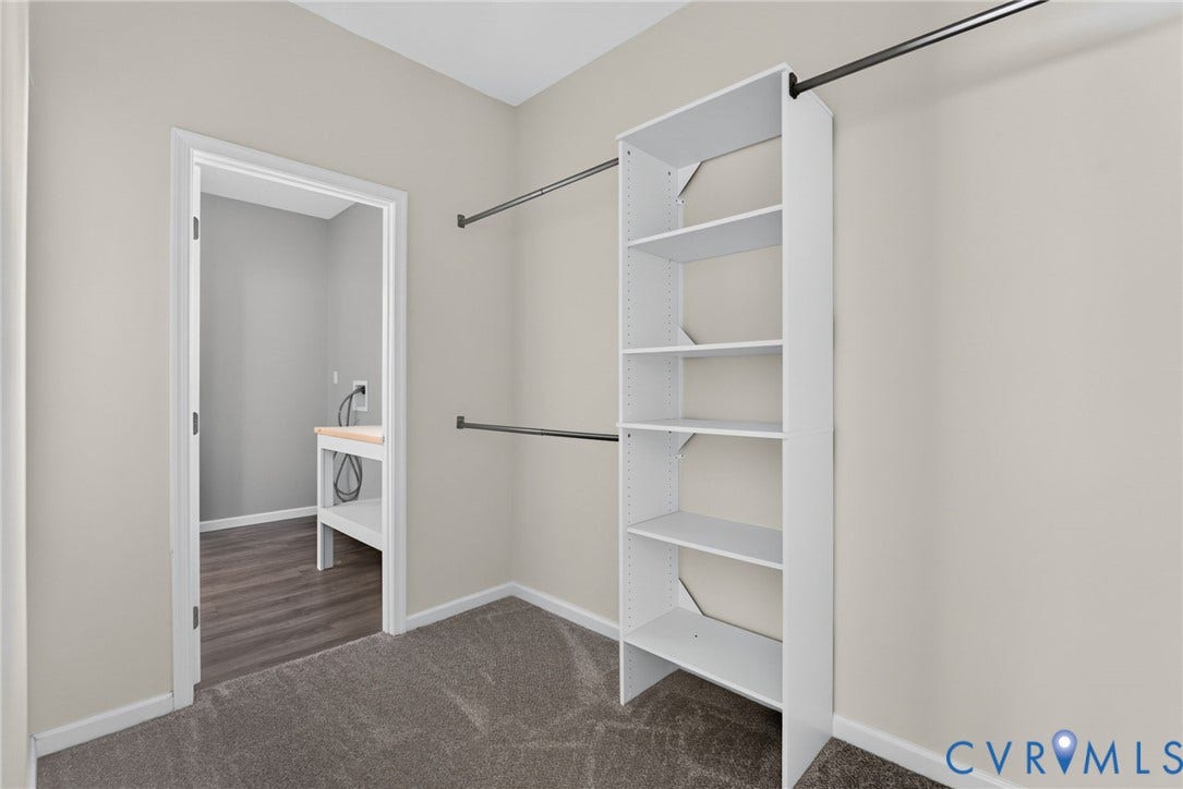 6852 Watch Harbour Circle, Hayes, VA 23072 Walk-in closet featuring built-in shelving, dual hanging rods, and neutral-toned carpeting