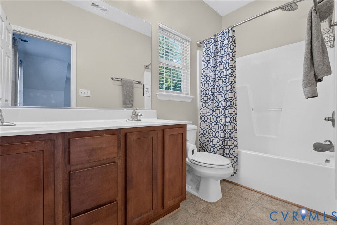 6852 Watch Harbour Circle, Hayes, VA 23072 Double vanity with wood-finish cabinetry and white countertops