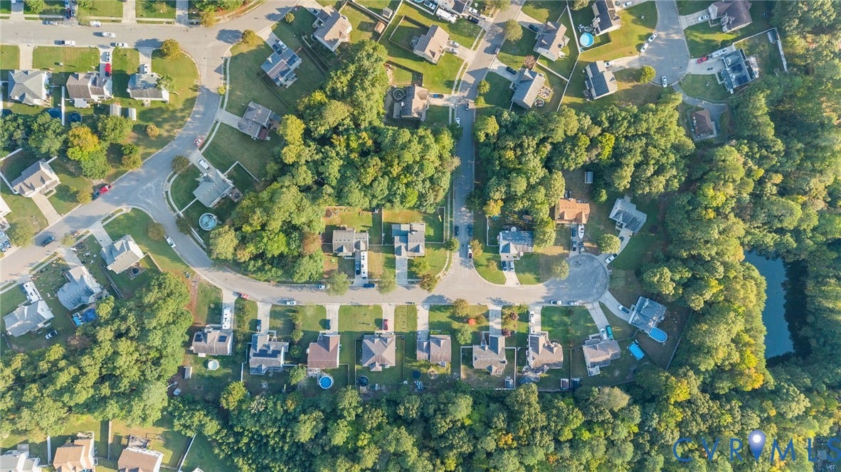 6852 Watch Harbour Circle, Hayes, VA 23072 Aerial perspective of a residential neighborhood featuring cul-de-sac streets, mature trees, and a pond