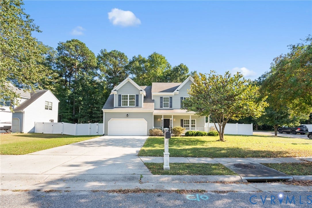 6852 Watch Harbour Circle, Hayes, VA 23072 Two-story residence with a covered front porch, attached two-car garage, dormer window, and a concrete driveway