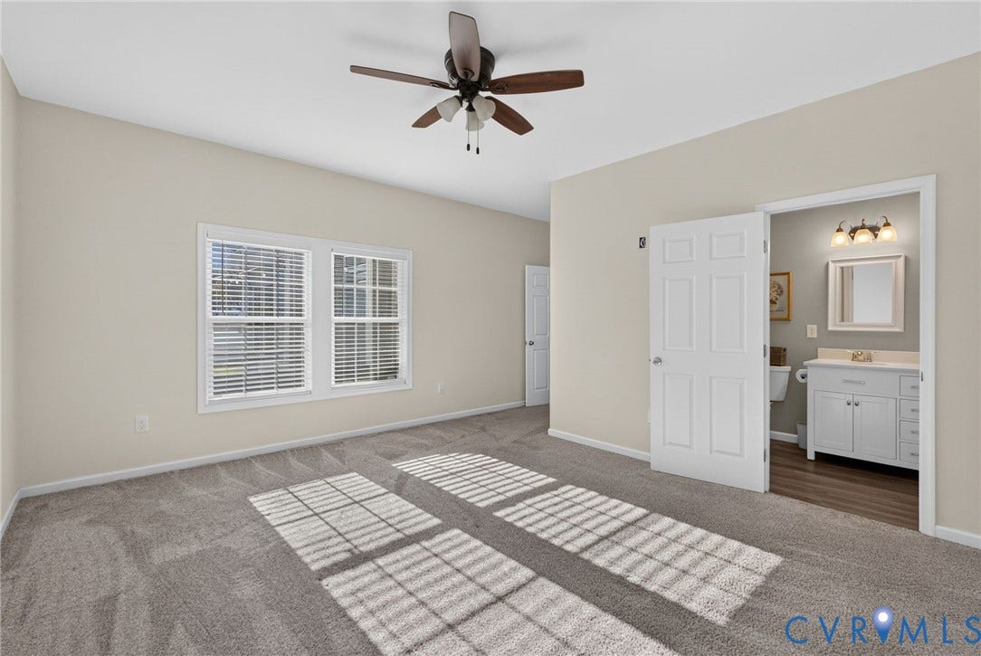 6852 Watch Harbour Circle, Hayes, VA 23072 Spacious room featuring neutral carpeting, a ceiling fan, and multiple windows with blinds