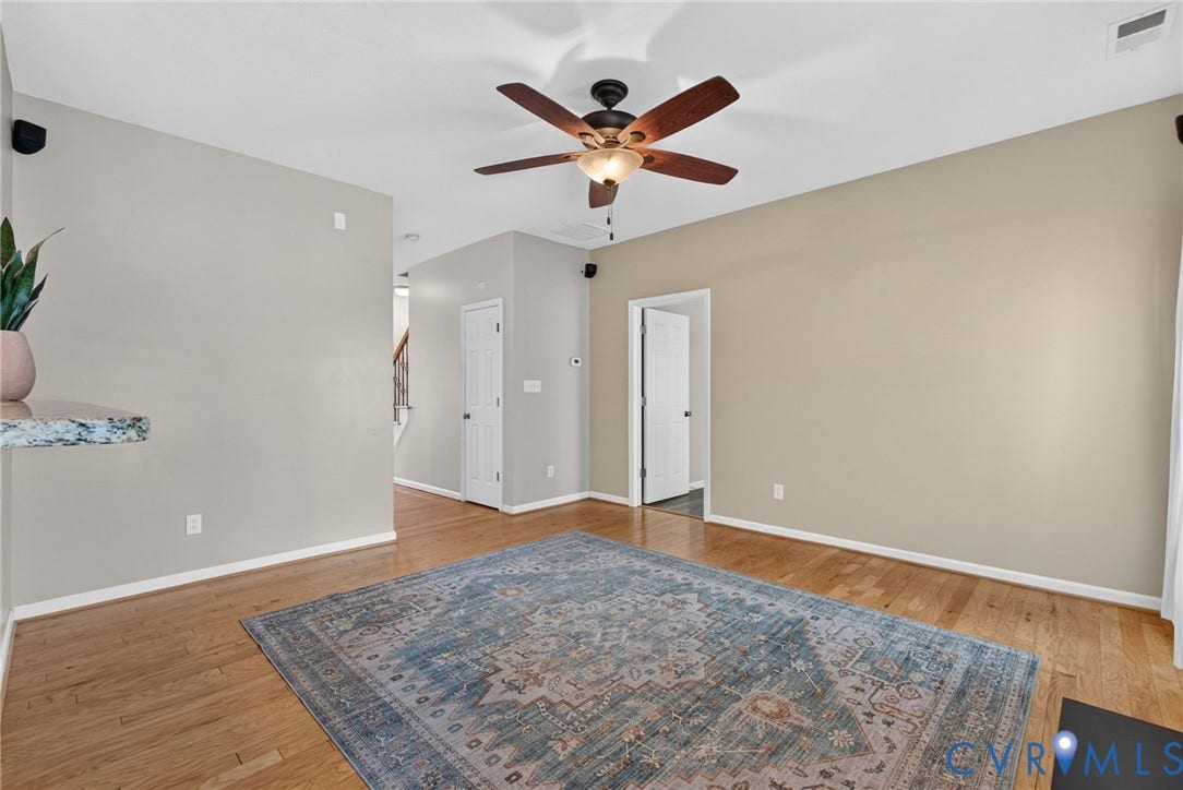 6852 Watch Harbour Circle, Hayes, VA 23072 Hardwood flooring with a matte finish, ceiling fan with integrated lighting, and neutral wall tones