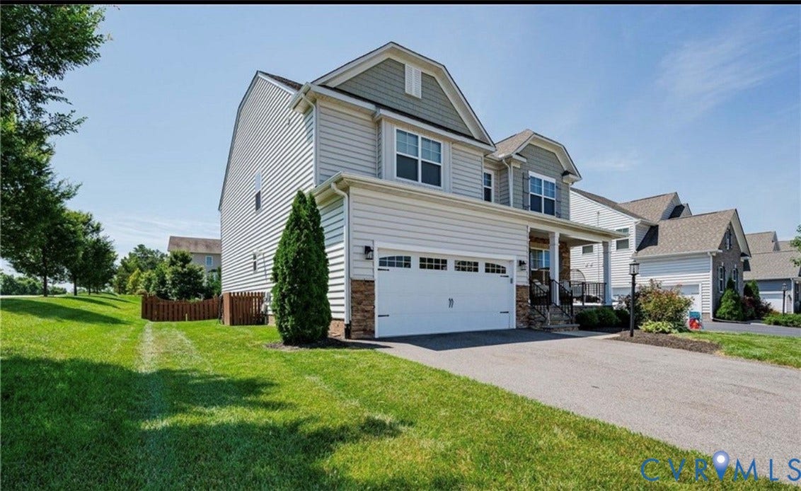 16001 Lost Crop Drive, Moseley, VA 23120 Two-story residence featuring siding and stone accents, a covered front porch, and an attached two-car garage