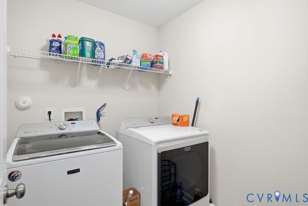 2490 Mountain Road, Glen Allen, VA 23060 Laundry area featuring white heavy-duty washer and dryer, wall-mounted wire shelving, and dedicated utility connections