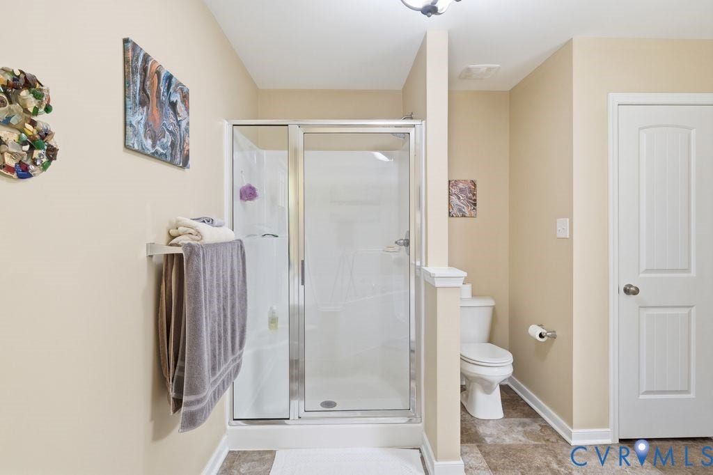 2490 Mountain Road, Glen Allen, VA 23060 Walk-in shower with a glass enclosure, tile-surround stall, two-panel interior door, and neutral-tone flooring