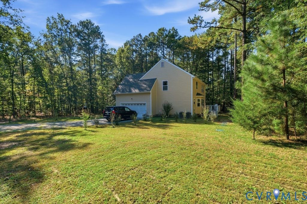 2490 Mountain Road, Glen Allen, VA 23060 Two-story exterior with light-toned siding, asphalt shingle roof, attached garage, and extensive surrounding forest foliage