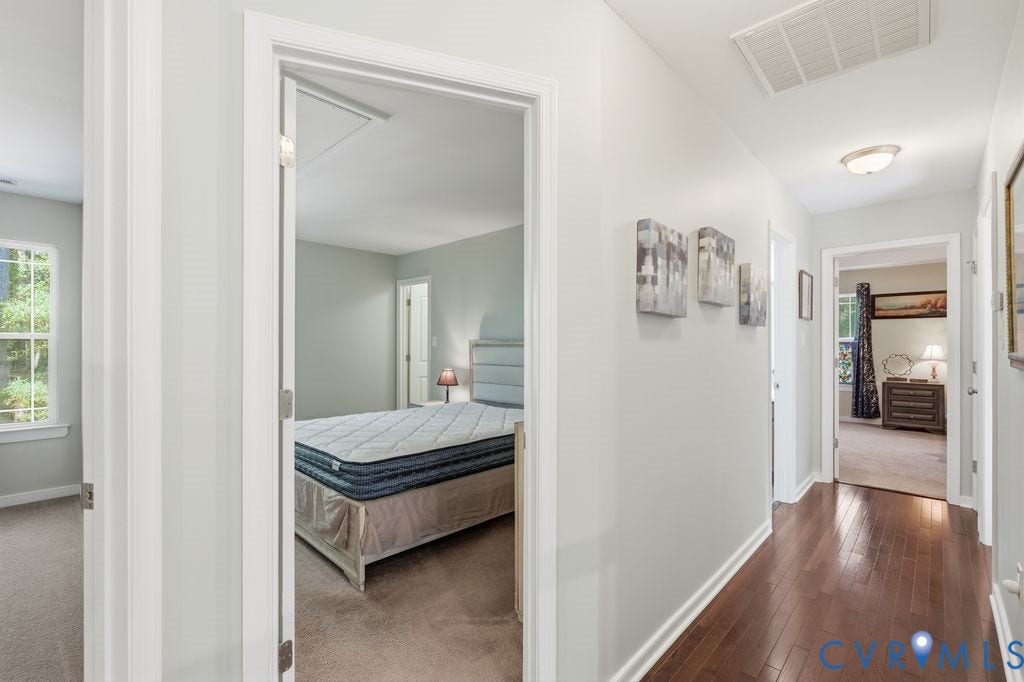 2490 Mountain Road, Glen Allen, VA 23060 Interior hallway featuring wood-finish flooring, neutral wall paint, and multiple entry points with crisp white door casings