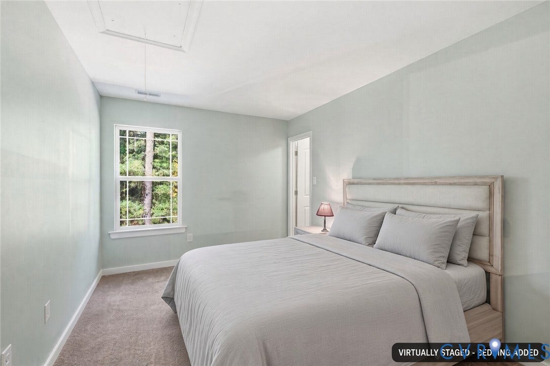 2490 Mountain Road, Glen Allen, VA 23060 Neutral wall paint, plush carpeting, and double-hung window with exterior greenery. Virtually staged - bedding added.