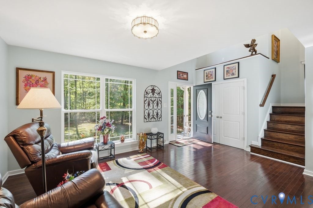2490 Mountain Road, Glen Allen, VA 23060 Foyer featuring wood-finish flooring, dark-toned staircase with wood treads, multi-pane windows, and a decorative flush-mount ceiling fixture